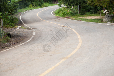 园景弯曲的公路是不多有树的路边巷道图片