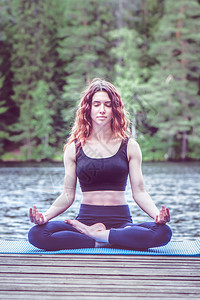 运动穿着瑜伽姿势的美丽女孩在Lotus湖位置上Padmasana安抚健康生活方式的概念拉伸平衡图片