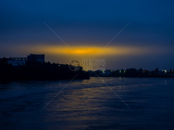 水蓝色的黑暗天和黄色城市灯光从夜之河的空上看到城市黄色灯光的反射夜晚图片