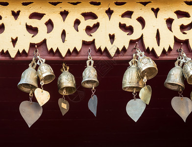 宗教的戒指装饰泰国教堂区木屋的棚上不需要财产放行的心形尾巴小黄铜铃用于装饰泰国教堂区的木叶子文化图片