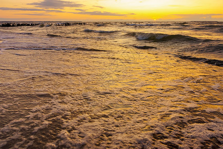 海上日落阳光下的海浪红色海浪上的日落颜色季节多云的图片