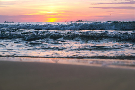 黄色的冷静海滩上日落阳光下的海浪红色海浪上的日落图片