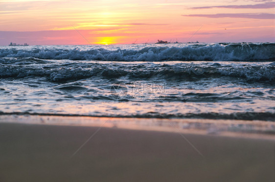 黄色的冷静海滩上日落阳光下的海浪红色海浪上的日落图片