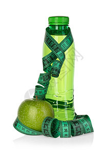 苗条的饮食与绿苹果用水瓶和白色背景隔离的磁带措施相容减肥概念并配有绿苹果饮水瓶和胶带药物图片
