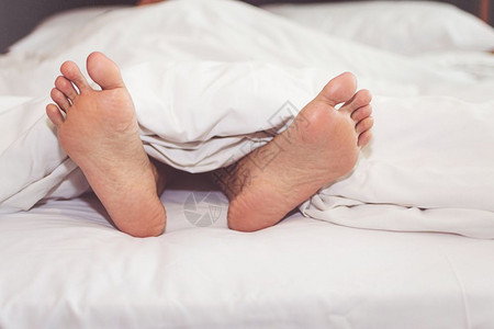 新生爱柔软的女人在家里床上脚露出双图片