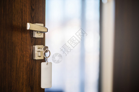 金属在空旅馆房间或日背景模糊的公寓锁中用钥匙把现代木制门手和钥匙关上半闭合的两边打开现代木制门把手屋入口图片