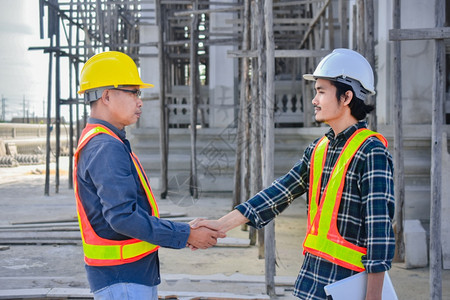 建筑师工作握手概念两个工程师握手关于工地建设的成功程项目男人图片