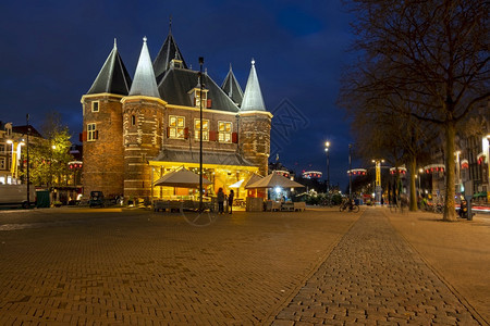 历史镇餐厅在阿姆斯特丹的Nieuwmarkt圣诞节日落时与阿姆斯特丹Waag大楼图片