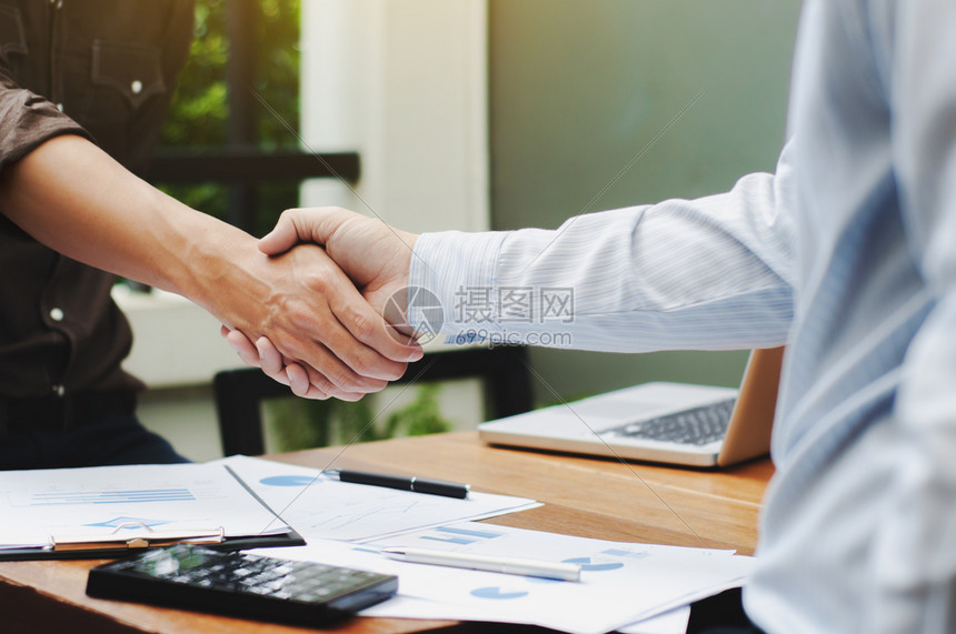 利润商业估值两名企主管与表上数据文件握手并的密切接触图片