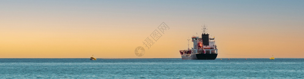 旅行油船日落时在公海上航行的运输船全景天空图片
