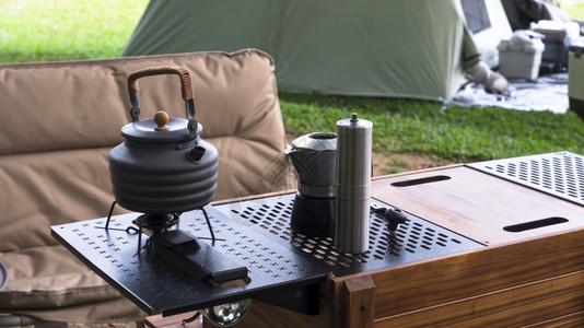 露营桌上的黑水壶和咖啡研磨机图片