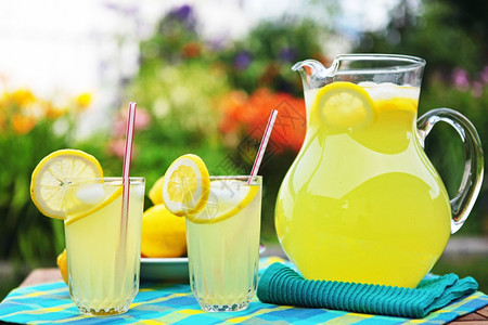 花朵解渴清的柠檬水在外边一个美丽的风景后院里供应投手图片