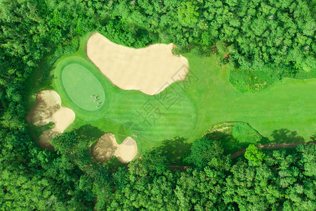 高尔夫球场的空中景象高尔夫球把放绿色手一种草地图片