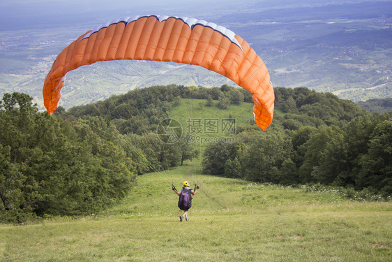 跳从山边缘起飞的滑翔伞在克罗地亚杰特迪绿色速度图片
