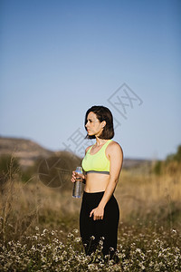 场地户外田里穿着运动服装的女童饮水在田里穿运动服的女孩饮水合作用图片