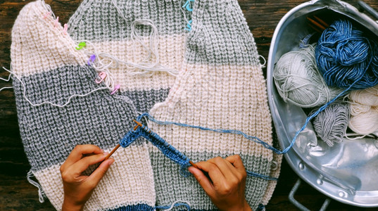 爱好人类在最顶端越南妇女手与毛球一起制作冬季服装女织毛羊衣休闲活动在家编织做手工艺服饰以及女士图片