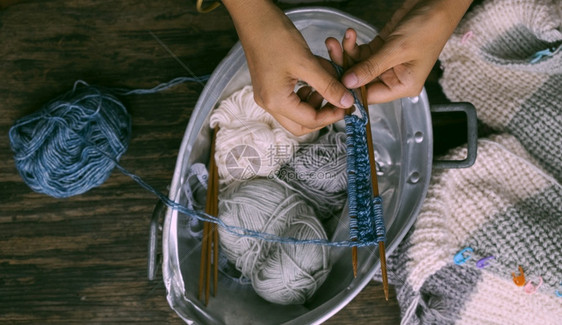 在最顶端越南妇女手与毛球一起制作冬季服装女织毛羊衣休闲活动在家编织做手工艺服饰以及年轻的越南语工作图片