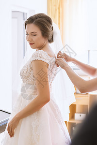 袍帮助新娘穿上婚纱的愈合姻图片
