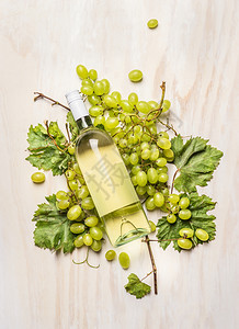 意大利语树枝上有新鲜葡萄树叶和白酒瓶子色木制背景顶视图酒精春天图片