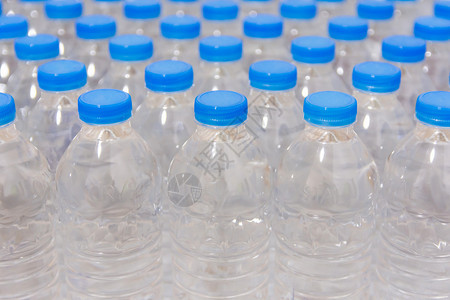 白色的一排水瓶带蓝盖的饮用水清除市场图片
