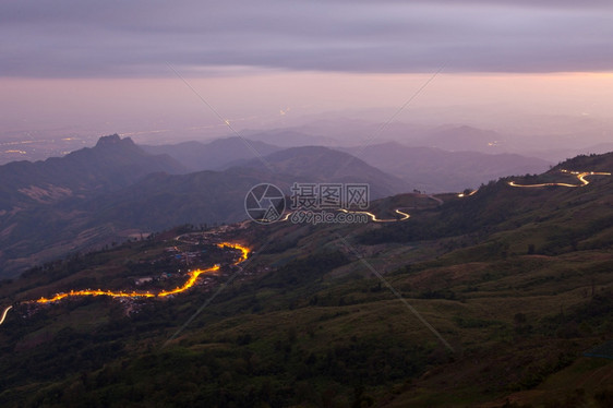 车辆夜晚的汽灯光在山上路旅游城市的图片