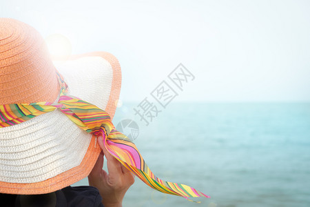 海滩遮阳板戴帽子的妇女在海边晒日光浴有复制空间和镜头跳蚤亚洲人图片