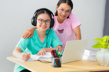 课年轻的介绍家庭快乐两个亚裔妇女寻找母亲是教师建议老指导女儿少学生在线习使用笔记本电脑教育从大学班在家中习里妈是她女儿的老师母亲图片