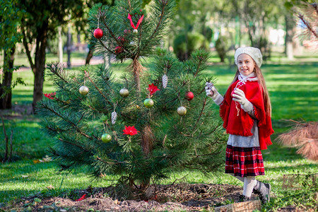 站在圣诞树旁的可爱女孩图片