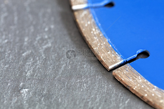 灰色混凝土背景上的菱形蓝色切割盘片段特写灰色混凝土背景上的金刚石切割盘片段金属工作力量图片