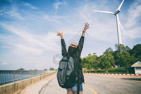 自由旅行者妇女与举起的手站在一享受着美丽的自然和欢呼年轻女背包车白种人常设健康图片