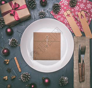 树圣诞概念明信片礼品盒圣诞玩具和锥体在灰色背景上围绕白色板块排成一列木制的丝带图片