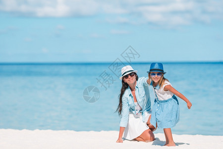 户外夏天小可爱女孩和年轻妈在热带海滩的妈还有女儿在海滩上图片
