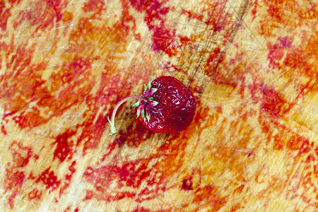 可口有机的健康一只小草莓在家里生长躺一块由草莓果汁制成的红板上由自制浆果和农用草莓制成背景图片