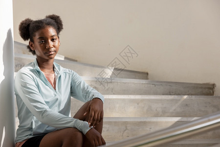 卷发女人的肖像坐在台阶和楼梯上向远看忧郁的年轻女士图片