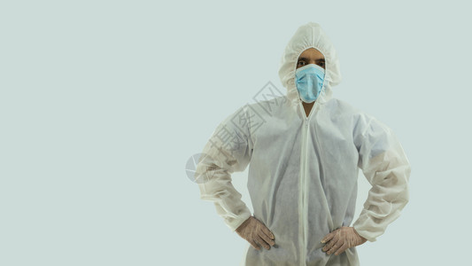治疗脸用蓝色面罩和生物防护服用白色背景的手绑腰部看医生前视镜图片