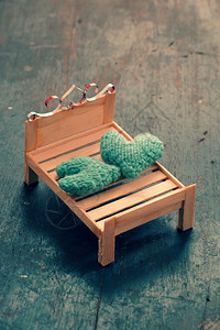 木制的两颗心要在一起情侣像插图一样相爱照顾和护绿色心放在手工制作的迷你家具上作为椅子摇摆在木本底床上抽象的室内图片