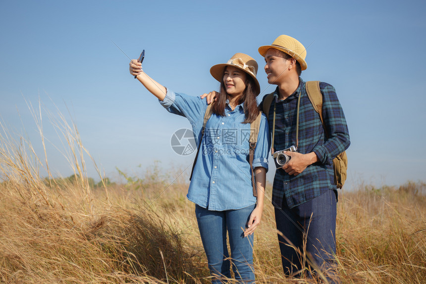 乐趣户外亚裔夫妇一起装扮用智能手机拍照美丽的图片