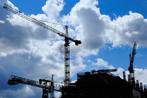 建筑工地有几架起重机覆盖蓝天和云层剪影技术机械图片
