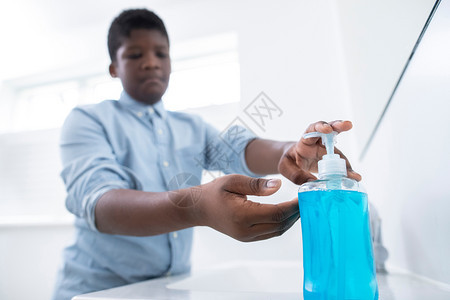 药物在家中用肥皂洗手预防感染的男孩在室内电晕图片