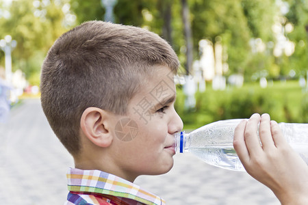 可爱的男孩喝着一瓶酒可爱的黑褐色男孩1岁欧洲的蓝色十一图片