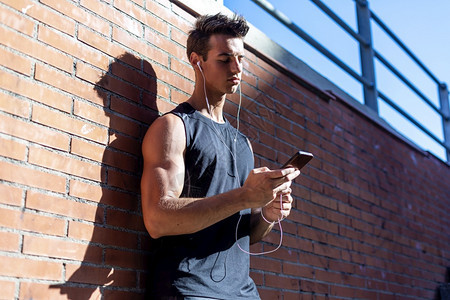 运动积极的电话男青年跑步子脱离训练休息时间图片