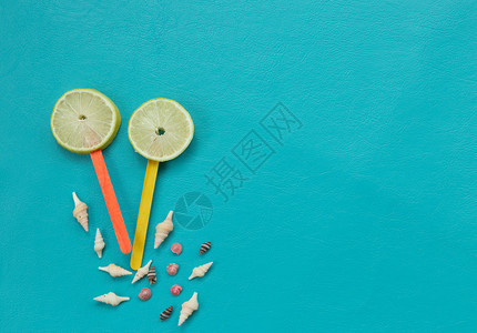 嘲笑蓝色背景海滩上的柠檬汁和贝壳平板模型设计丰富多彩的菠萝图片