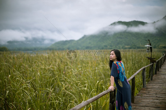 松弛蓝色的木制坐在码头上女人看着日落的美丽图片