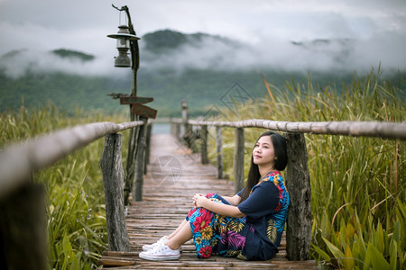 山瑜伽坐在码头上的女人看着日落的美丽松弛图片