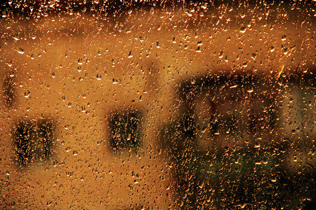 多层房屋背景的窗外雨下时滴在玻璃上的水下雨时窗外的水滴多层背景上的窗外雨下时玻璃上的水滴天气自然倾盆大雨图片