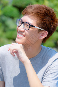 肖像积极的在泰国绿色自然背景的公园里带着快乐笑脸身戴眼镜的亚洲有趣少年男孩们都笑着男生图片