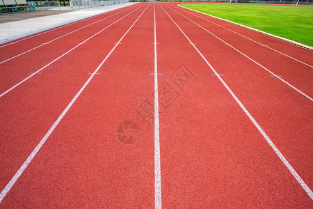 绿色橡胶体育场白线和户外体育场赛马红色橡皮道的纹理是8个田径和绿草地有铁轨足球场和的空运动赛跑者图片