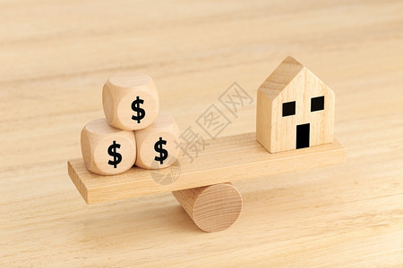 象征真实的木制玩具房和骰子锯上印有美元符号文字木制的图片