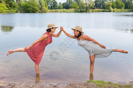 两个朋友站在一起条腿湖水中微笑请享用人们图片