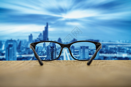 现代的生活清晰城市景色以眼镜片为焦点其模糊的城市景色背清晰的眼镜潮人图片